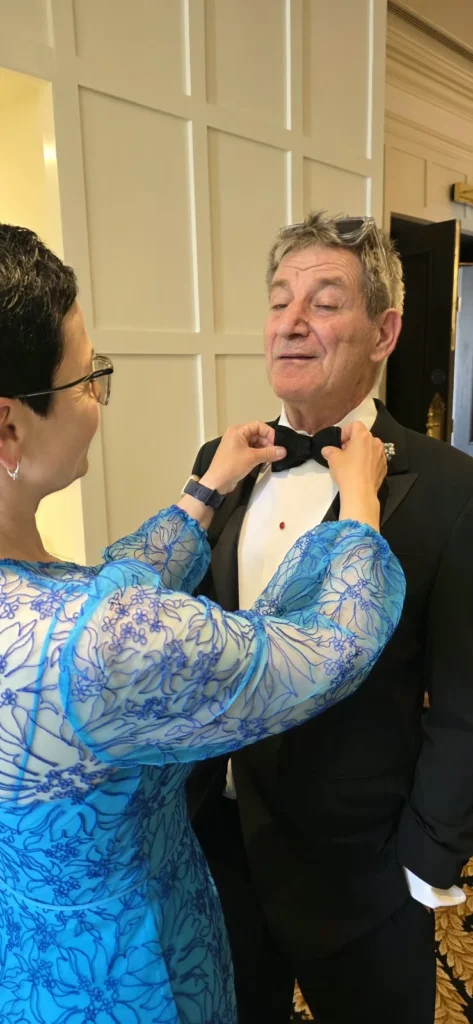 Wedding planner Oana adjusting a guest’s bow tie before the ceremony